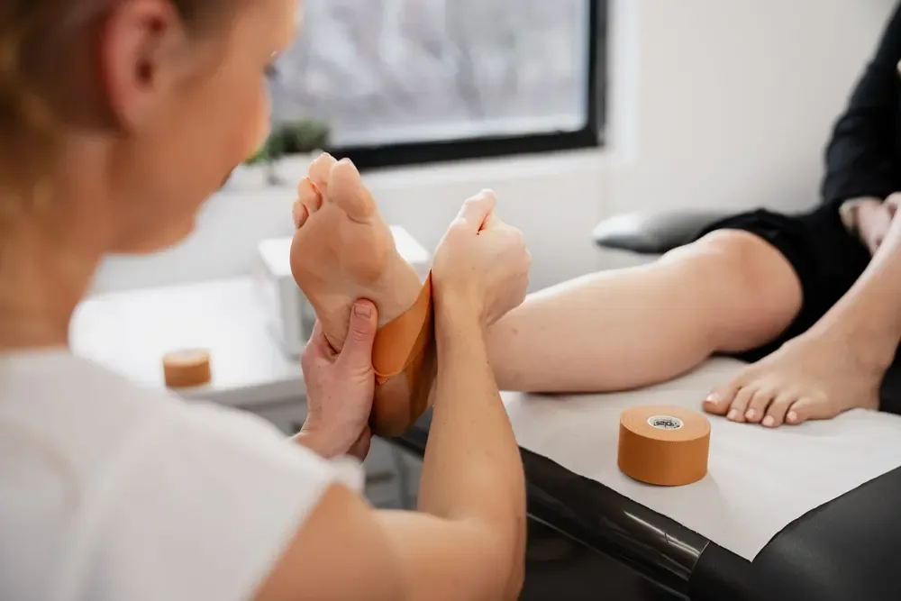 Clinician applying rigid strapping tape to a runner's foot